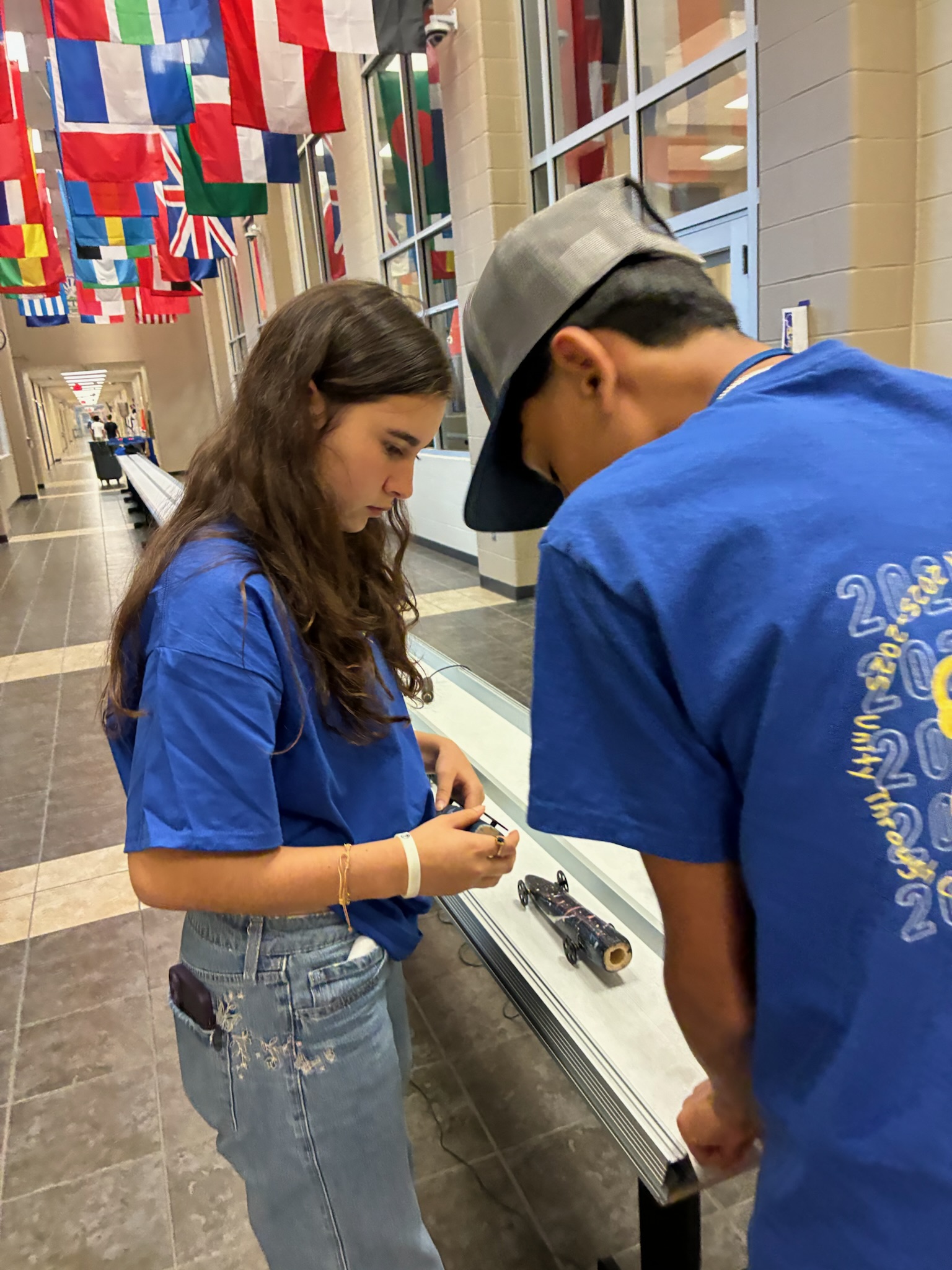 TSA members testing a mousetrap car in the hallway